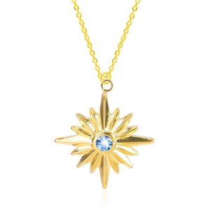 Macro shot of gold star pendant necklace with central blue crystal and fine chain