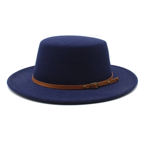Détail d'un chapeau de marin bleu marine en laine avec bande décorative en cuir marron