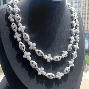 Détail du collier double rang argenté avec pierres scintillantes et maillons en fleurs