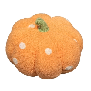 Plush orange pumpkin pillow with white polka dots and green stem for home decor