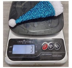 Detailed view showing the 3g weight of a blue sequined mini Christmas hat decoration