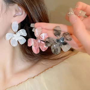 Detail view of retro marble-textured resin flower earrings in white pink and black