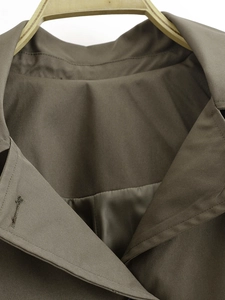 Detailed macro shot of olive green twill coat fabric texture with smooth lining