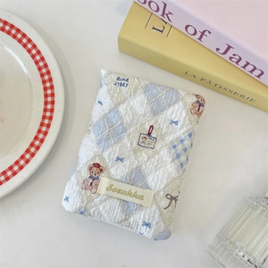 Detail of blue quilted fabric passport holder with cute bear patterns and Sozakka label