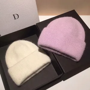 Thick angora rabbit hair knitted beanie hats in cream and lilac with ribbed texture