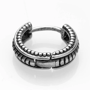 Macro detail of silver stainless steel hoop earring with vintage textured scale pattern