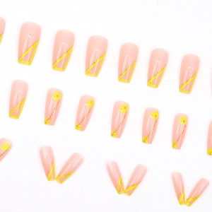 Long coffin fake nails with yellow flower patterns and glitter diagonal French lines
