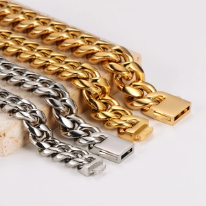 Bracciali a catena cubana in acciaio inossidabile oro e argento su una base di pietra