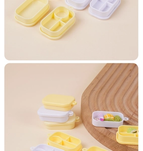 Detailweergave van de miniatuur lunchboxmodellen met verdeelde vakken voor poppenhuizen