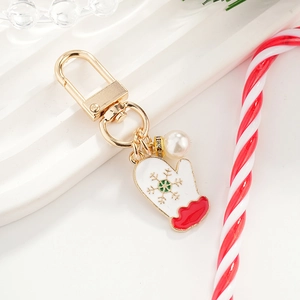 Christmas enamel glove keychain with white pearl on a festive background