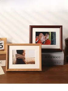 Detail of premium light and dark wood photo frames with white matting on a wooden desk