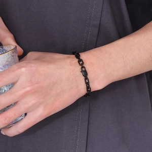 Close-up of a bold black stainless steel chain bracelet on wrist with lobster clasp