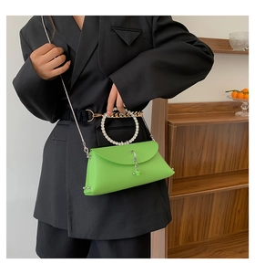 Macro shot of bright green jelly bag with a round rhinestone-studded top handle