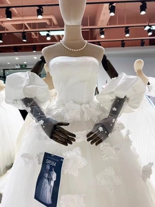 Detail view of bridal wedding gown with 3D floral waist applique and puff sleeves