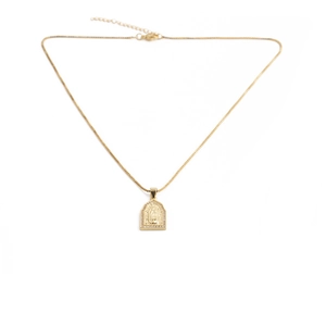 Detail of rectangular gold pendant with religious relief and sparkling crystal borders