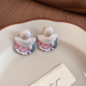 Détail de boucles d'oreilles en métal brossé avec imprimé floral cactus du désert