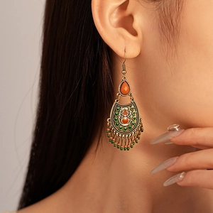 Detail shot of vintage bohemian drop earrings with resin beads and metallic tassels