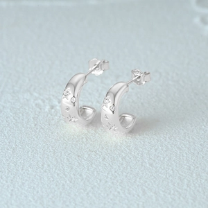 Detailed macro view of S925 sterling silver C-shaped star earrings with cubic zirconia