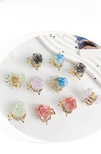 Detail of mini resin rose hair claws with glitter finish and sparkling rhinestones