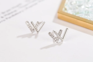 Macro shot of silver W-shaped earrings with shimmering cubic zirconia stones inlay