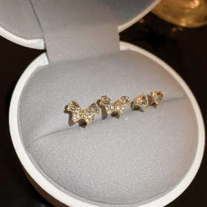 Detailed view of butterfly and heart stud earrings with cubic zirconia in a jewelry box