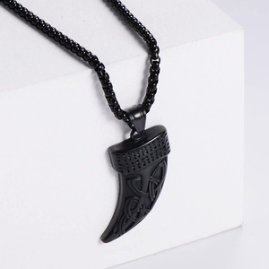 Matte black Celtic knot wolf tooth pendant necklace on minimalist white display stand