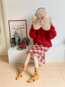 Close-up of cozy gingerbread man plush pillow and festive Christmas themed crew socks