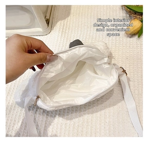 Close-up of white plush cloud bag showing interior zipper closure and nylon strap