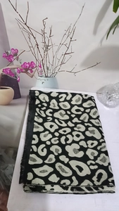 Detail shot of leopard print scarf with soft tassels and thick cashmere texture