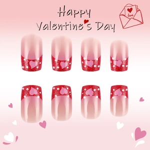 Detail of red glitter French tips with heart patterns on glossy Valentine press-on nails