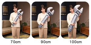 Three sizes of creative wrench-shaped plush pillows shown with a model for scale