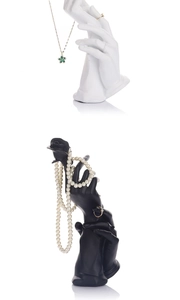 Macro shot of black and white resin hand-shaped jewelry stands for rings and necklaces
