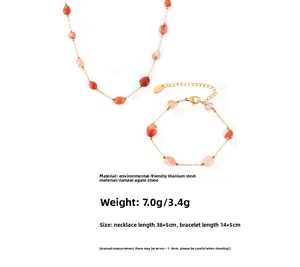 Detail view of gold-plated titanium steel jewelry set with red and pink natural agate stones