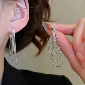 Boucles d'oreilles argentées à pompons multicouches avec un design créoles à trois rangs