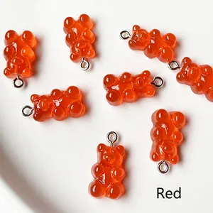Close-up of red gummy bear resin charms with silver loops for DIY jewelry making