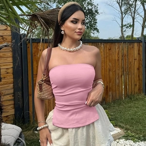 Vue détaillée d'un top tube rose sans bretelles avec une jupe en dentelle blanche au jardin