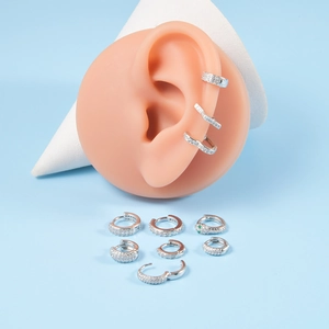 Detailed view of silver hoop earrings with zircon butterfly and snake studs on ear model