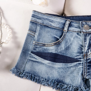 Detailansicht der blauen Denim-Shorts mit ausgefransten Säumen und Vintage-Waschung