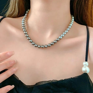 Detailed view of grey pearl necklace on model's neck for an elegant collarbone look