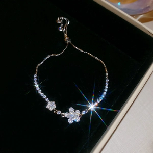 Macro detail of adjustable flower bracelet with sparkling zircons on black velvet base