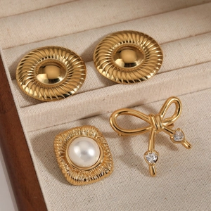 Set di spille vintage dorate con perle e zirconi a cuore in un portagioie in legno