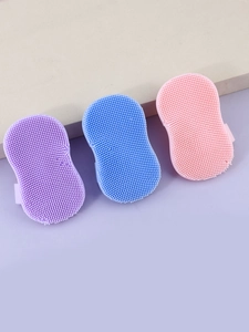 Three colorful silicone facial brushes with soft bristles and secure finger straps
