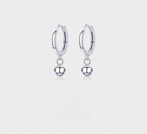 Close-up of a minimalist s925 sterling silver earring with a polished ball pendant and hoop