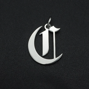 Macro shot of silver stainless steel gothic letter C pendant with a polished finish