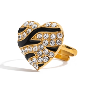 Golden heart ring with black enamel zebra stripes and white rhinestones on white background