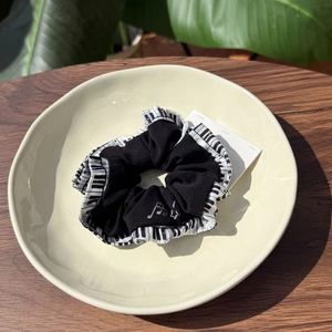 Detail of piano keyboard fabric scrunchie with musical note and star embroidery