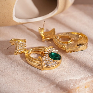 Vue détaillée de boucles d'oreilles dorées vintage avec pierres vertes et strass clairs