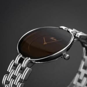Detailed close-up of a vintage silver watch with a brown dial and sleek metal strap