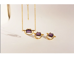Detail view of gold-plated jewelry set featuring purple zircon geometric pendants