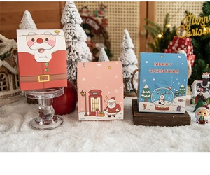 Three-tiered display of decorative Christmas gift boxes featuring Santa and Snowman designs